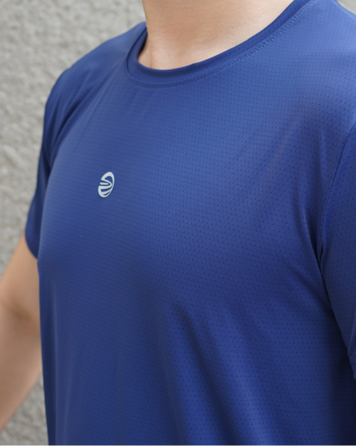 Person wearing a PULSE ATOMWEAVE athletic shirt with a logo against a gray background