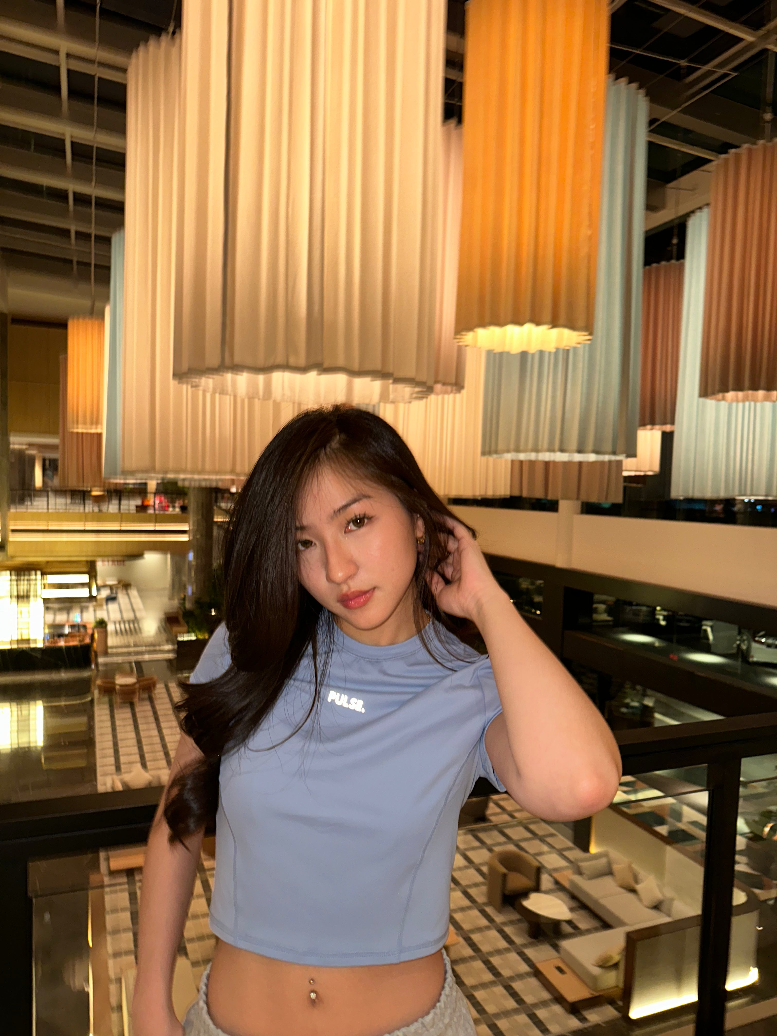 Woman posing in a modern interior setting with decorative lights